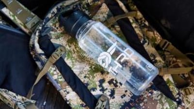 A water bottle on a backpack, hunting in summer tips for staying hydrated concept.