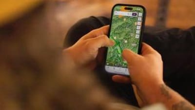 Close-up of hunter using phone showing topo map, how to read topo maps for deer hunting concept.