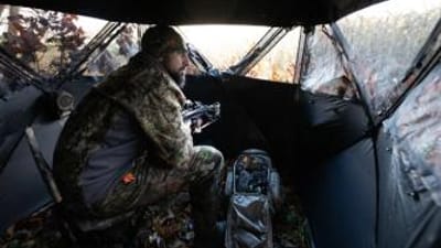 A hunter sits in a ground blind, getting a Georgia hunting license concept.