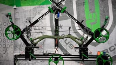 A compound bow on a stand for maintenance.