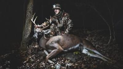 A hunter poses with a trophy buck.
