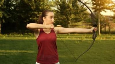 A woman draws a recurve bow.