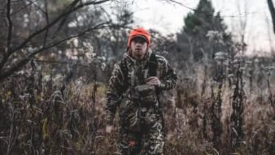 A hunter walking in the brush while wearing camo, get ready for opening day of gun season concept.