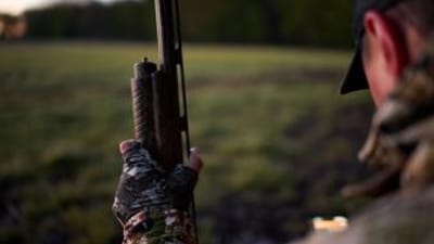 Hunter with shotgun and HuntWise app, best dove hunting shotgun concept.