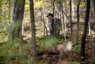 A hunter in camo with gear in the woods, do scent blockers work concept.