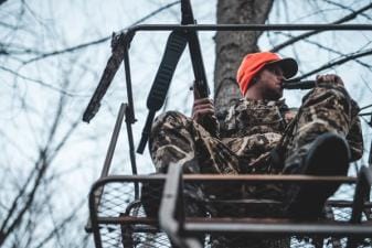 A hunter uses a deer call, calling bucks concept.