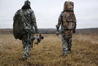 Two hunters walking in a field with text "5 Fall Hunting Tips"