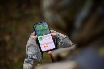 FGBLOG hunter looks at phone showing HuntWise WindCast