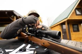 A hunter adjust a site on a hunting rifle.