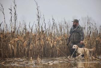A hunter hunts waterfowl with a dog, ethics in hunting concept.