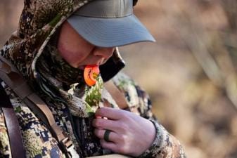 A hunter uses a turkey call, California turkey season concept.