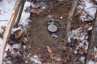 Live animal trap set in the dirt, how to start trapping concept.