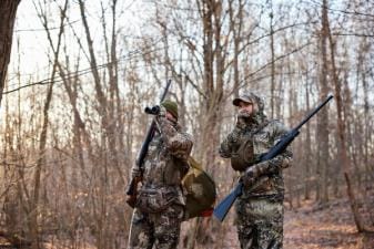 Hunters in the field looking for game, get an Arkansa hunting license concept.