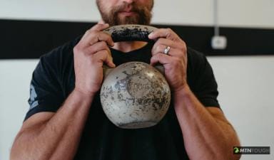 A man holds a dumbbell, hunting exercises to stay in shape concept.