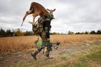 A hunter carries a deer decoy for a hunt.