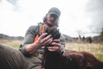 A hunter holds a bear paw, black bear hunting concept.