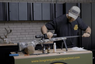 Hunter cleaning a rifle, post season rifle care concept.