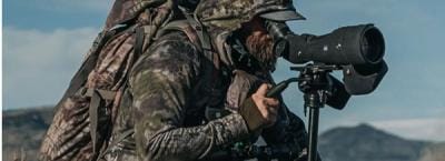 A hunter in camp use a spotting scope, best spotting scopes concept.