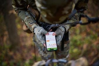 Hunter used HuntWise on phone while in tree saddle, how to use a hunting app concept.