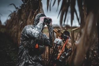 Hunters using binoculars, hunting in the wind concept.