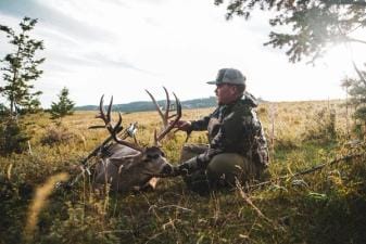 A hunter holds up the head of a deer kill, finding big bucks on public land concept.