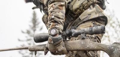 Close-up of a rifle in a hunter's hand, best caliber for whitetail hunts concept.