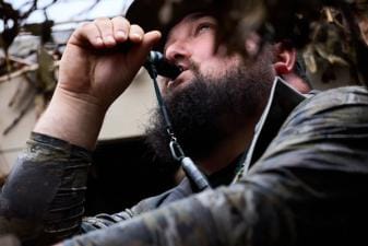 Hunter using a duck call, mastering the best duck calls concept.