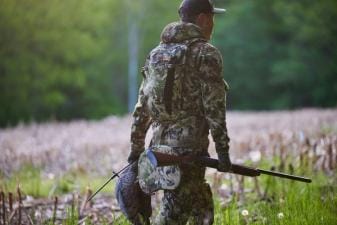 A hunter carries a turkey decoy into the field.