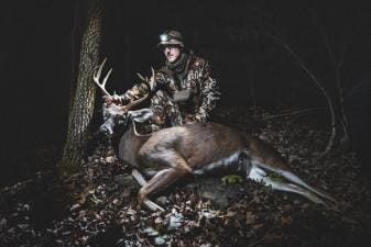 A hunter poses with a trophy buck.